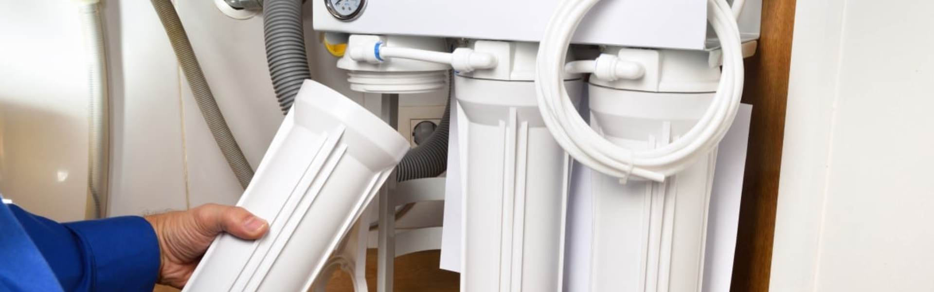 Technician servicing a home water filtration system in Massachusetts